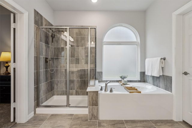 bathroom featuring a stall shower and a bath