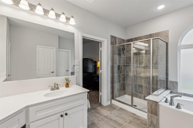 full bathroom featuring a garden tub, a shower stall, and vanity