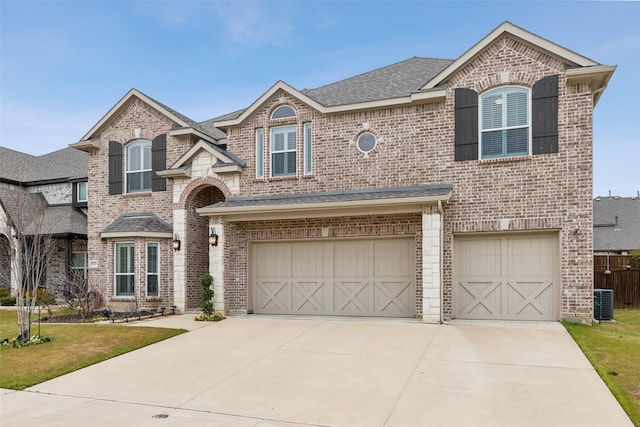 view of front of house featuring brick siding, an attached garage, and roof with shingles