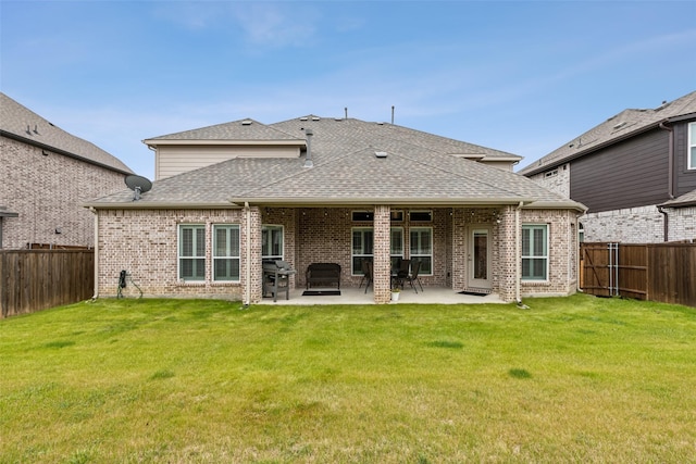 back of property featuring a fenced backyard, a yard, and roof with shingles