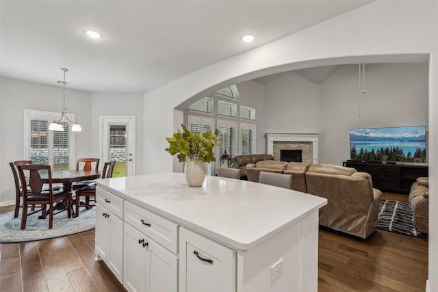 kitchen with a stone fireplace, white cabinets, dark wood-style flooring, and recessed lighting