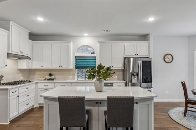 kitchen featuring appliances with stainless steel finishes, a breakfast bar area, visible vents, and under cabinet range hood