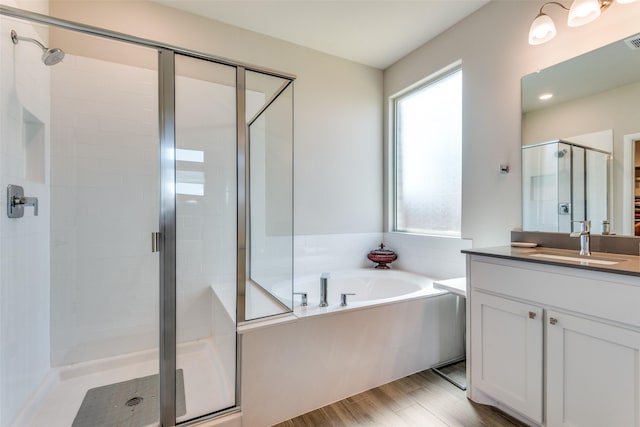 full bathroom with a shower stall, visible vents, a bath, and vanity