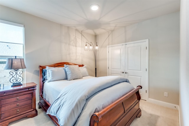 bedroom featuring light carpet, a closet, and baseboards