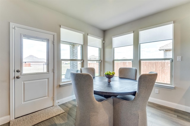 dining space featuring light wood finished floors and baseboards