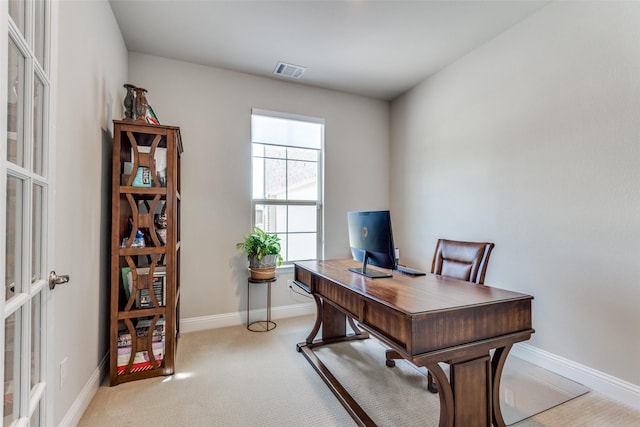 office area featuring baseboards, visible vents, and light colored carpet