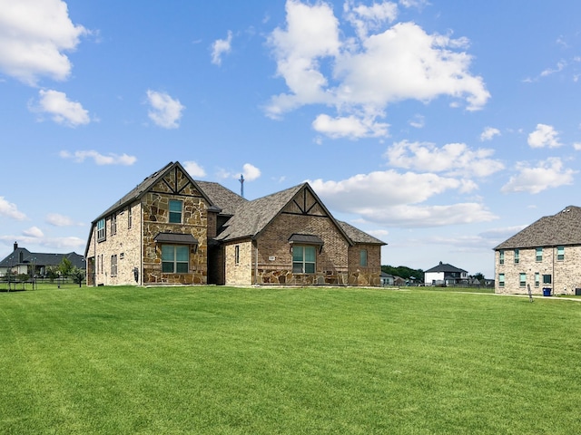 view of front of house with stone siding and a front lawn