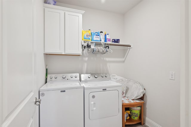 laundry room with washing machine and dryer, cabinet space, and baseboards