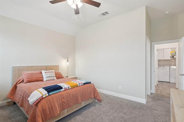 bedroom with washing machine and dryer, light carpet, visible vents, baseboards, and vaulted ceiling