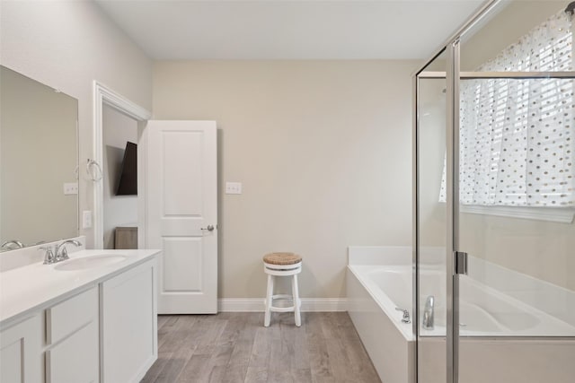 full bathroom featuring vanity, wood finished floors, a bath, and a shower with door