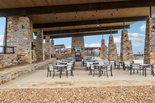 view of patio / terrace featuring a large fireplace, a city view, and a gazebo