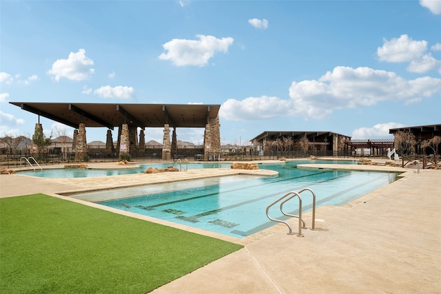 community pool with fence and a patio