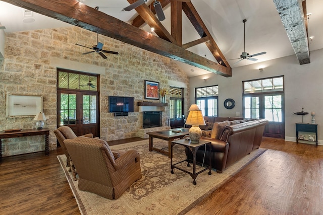 living area featuring high vaulted ceiling, a fireplace, wood finished floors, french doors, and beam ceiling