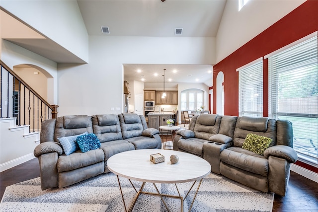 living room featuring dark wood-style floors, baseboards, and visible vents