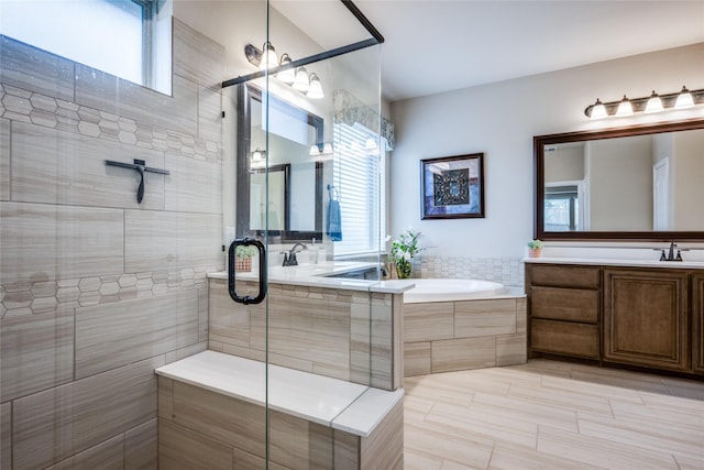 bathroom with a stall shower, a garden tub, and vanity