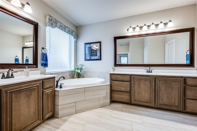 bathroom featuring a sink, a garden tub, and two vanities