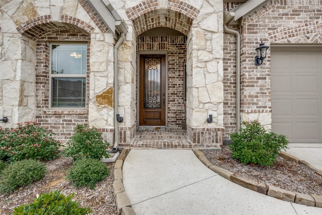 entrance to property with brick siding and an attached garage