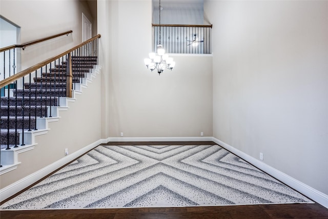 spare room with a chandelier, baseboards, and stairs