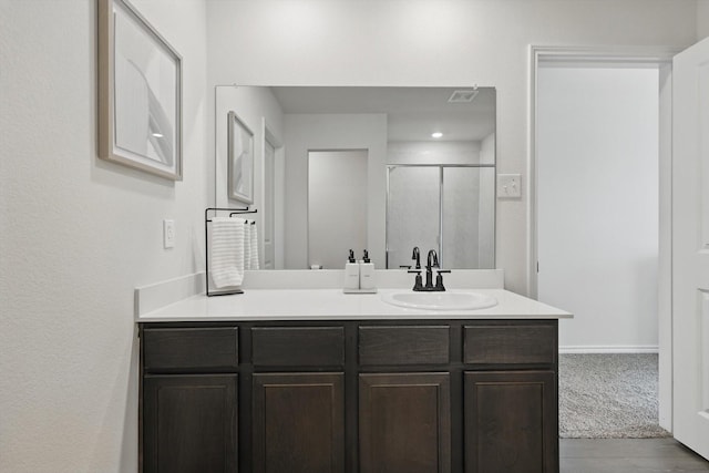 full bathroom with a stall shower, visible vents, and vanity