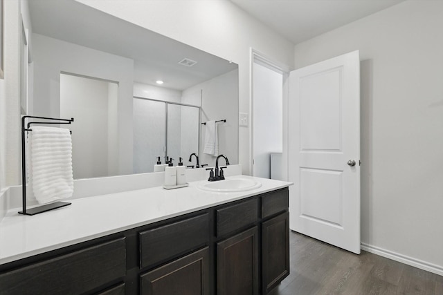 bathroom featuring recessed lighting, wood finished floors, vanity, baseboards, and a shower stall