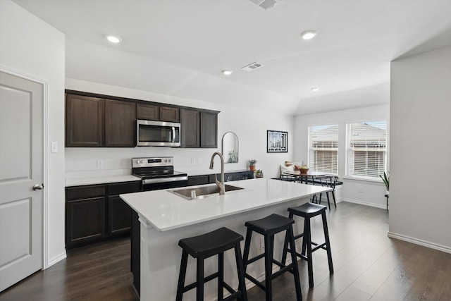 kitchen featuring dark wood-style floors, appliances with stainless steel finishes, a sink, and visible vents