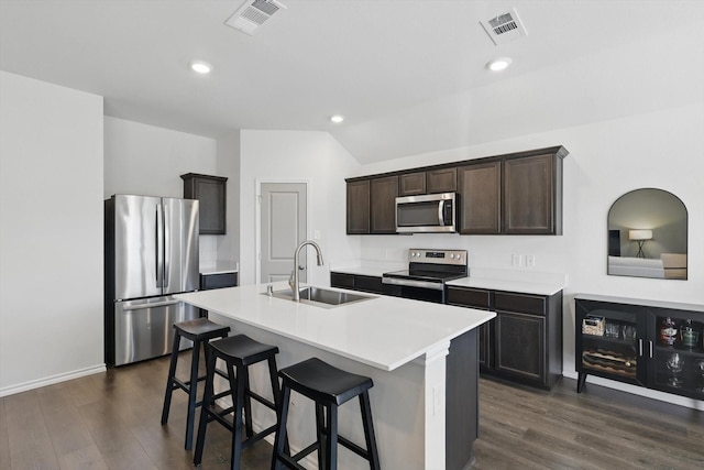 kitchen with stainless steel appliances, dark wood-type flooring, a sink, and visible vents