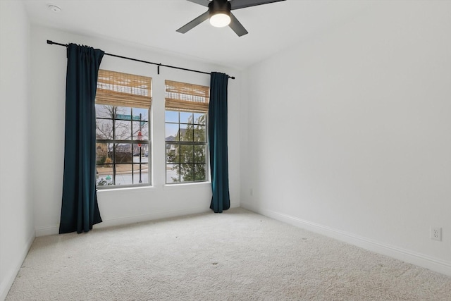 spare room featuring a ceiling fan, carpet, and baseboards