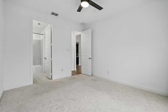 unfurnished bedroom with carpet, visible vents, ceiling fan, ensuite bath, and baseboards