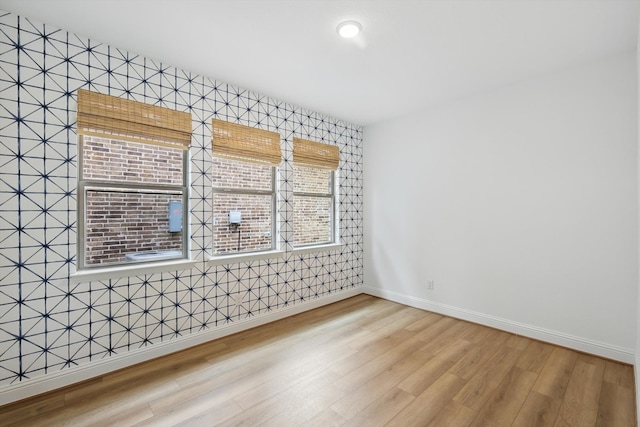 empty room with baseboards and wood finished floors