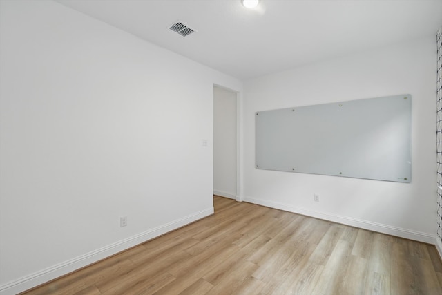 unfurnished room with visible vents, baseboards, and wood finished floors