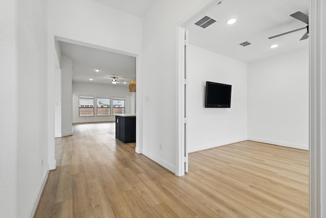 hallway featuring light wood-type flooring, baseboards, visible vents, and recessed lighting