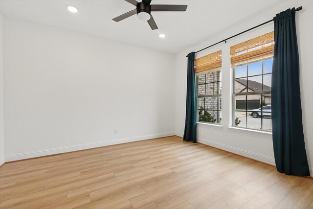 spare room with a ceiling fan, light wood-type flooring, visible vents, and baseboards