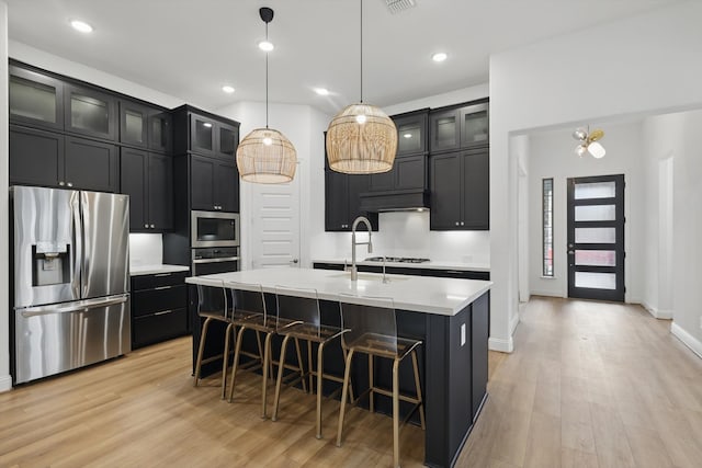 2821 Rosewood Way, Northlake, TX 76226 - kitchen with stainless steel appliances, light wood-type flooring, dark cabinets, light countertops, and recessed lighting