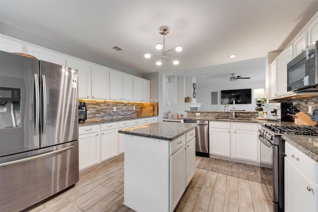 kitchen featuring white cabinets, visible vents, stainless steel appliances, and wood finish floors