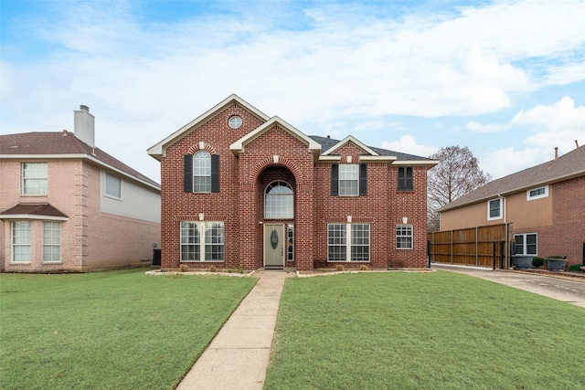 view of front facade with fence, a front lawn, and brick siding