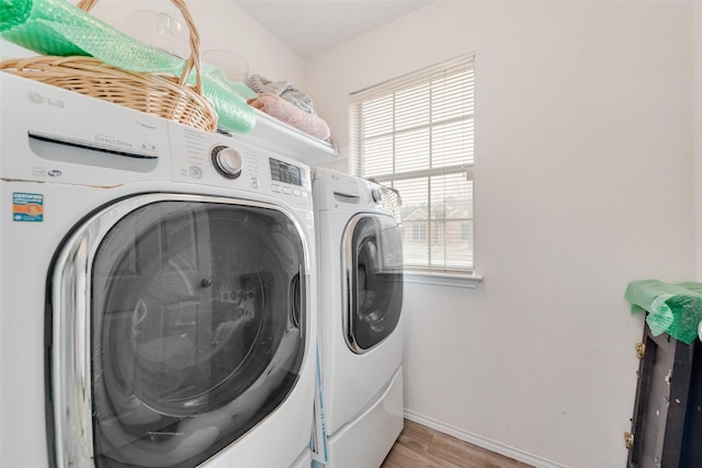 laundry area with washer and dryer, laundry area, baseboards, and light wood finished floors