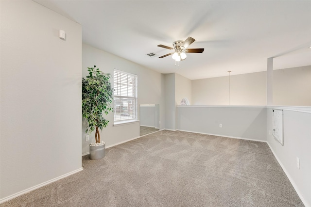 carpeted empty room with visible vents, ceiling fan, and baseboards