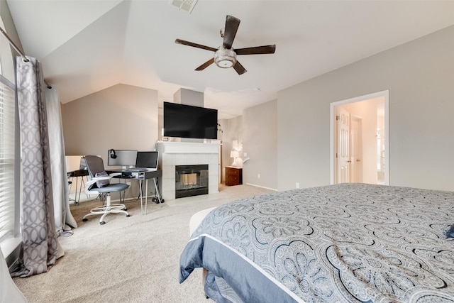 carpeted bedroom with vaulted ceiling, ceiling fan, a tile fireplace, and visible vents