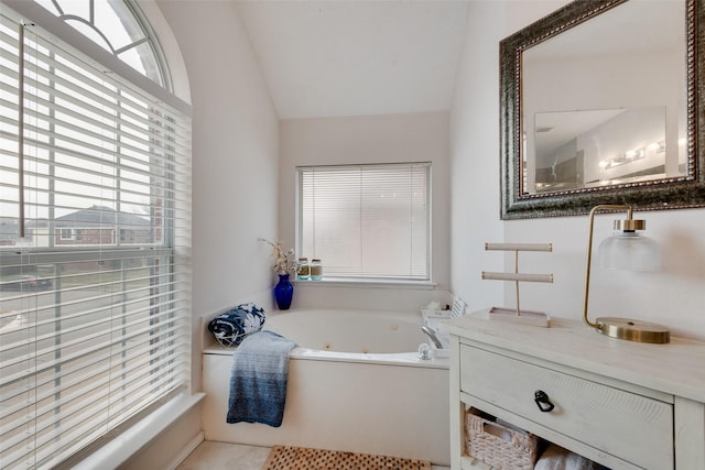 full bath with a whirlpool tub, lofted ceiling, and vanity