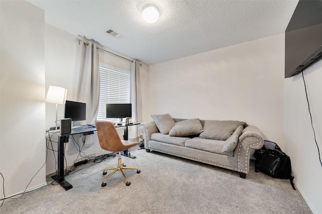 carpeted office space with a textured ceiling, visible vents, and baseboards