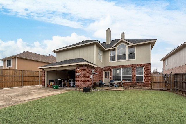 rear view of property featuring a yard, brick siding, driveway, and a fenced backyard