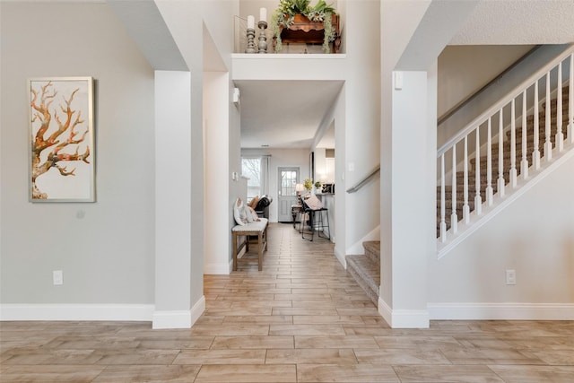 foyer featuring stairs, wood finished floors, and baseboards