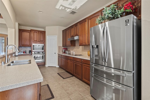 kitchen with visible vents, stainless steel appliances, light countertops, under cabinet range hood, and a sink