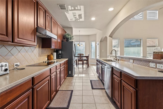 kitchen with stainless steel appliances, visible vents, light tile patterned flooring, a sink, and under cabinet range hood