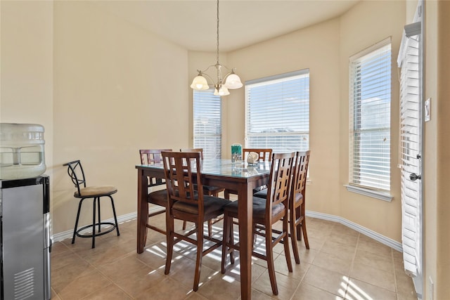 dining room with light tile patterned flooring, a notable chandelier, and baseboards