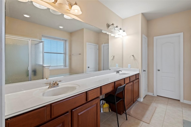 full bath with double vanity, a stall shower, a sink, and tile patterned floors