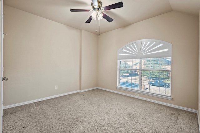 carpeted empty room featuring lofted ceiling, ceiling fan, and baseboards