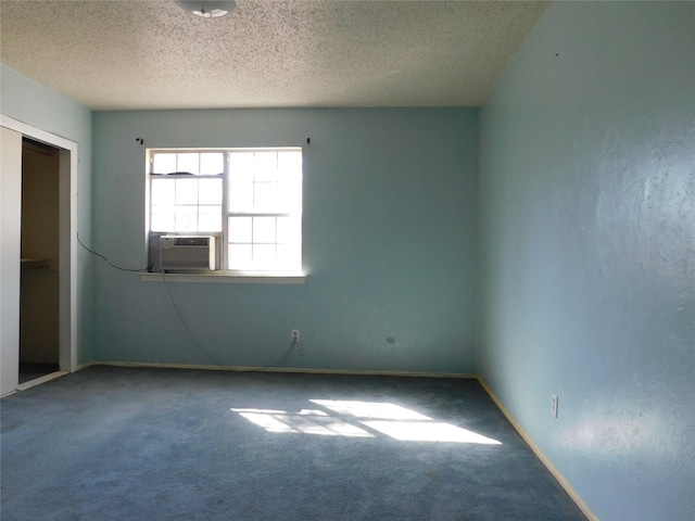 carpeted spare room featuring cooling unit, baseboards, and a textured ceiling