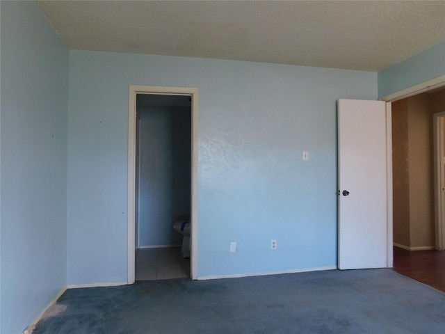 unfurnished bedroom featuring a textured ceiling and carpet