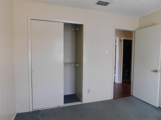 unfurnished bedroom featuring a closet, visible vents, and a textured ceiling